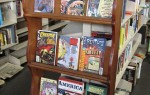 Photo of bookshelf containing various colorful comic books and hardcovers.