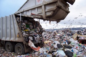 Packer truck dumps garbage at landfill.