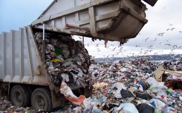 Packer truck dumps garbage at landfill.