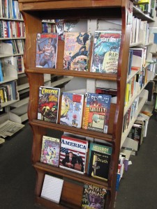 Photo of bookshelf containing various colorful comic books and hardcovers.